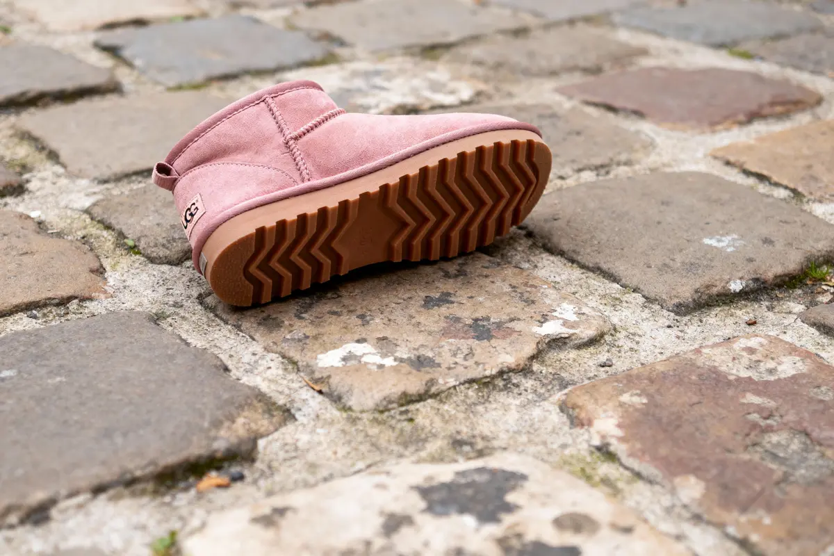 Une botte rose sur les pavés, vue semelle en zigzag.