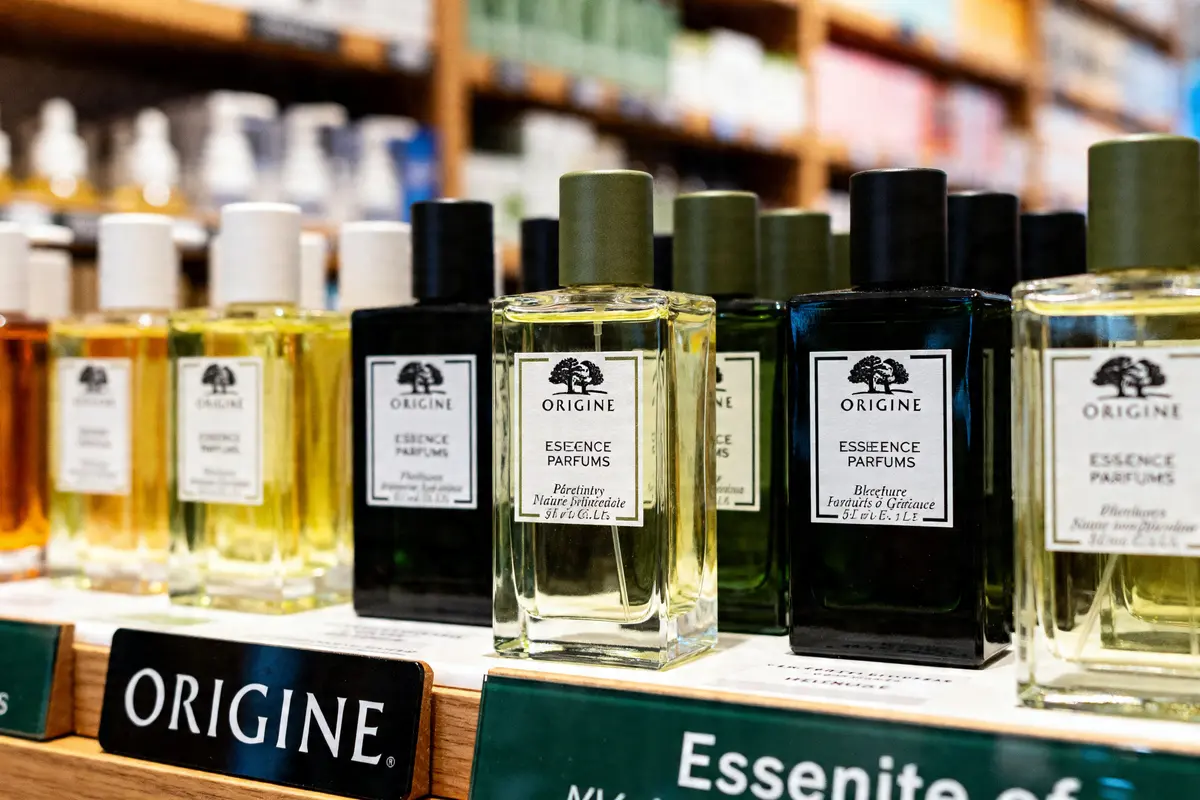 Rayon de parfums Origine en magasin expliquant pourquoi Origines Parfums est moins cher
