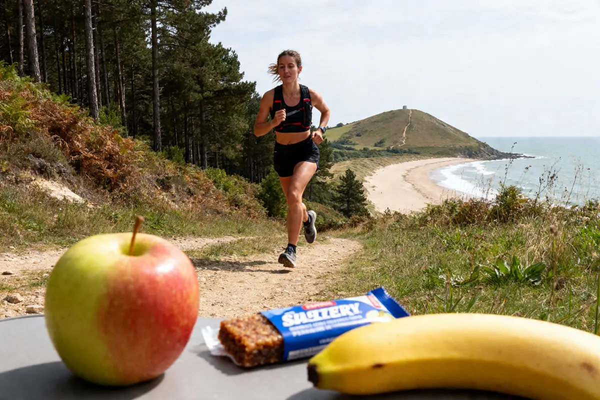 Une femme court sur un sentier côtier avec fruits visibles sur site sportrip.fr