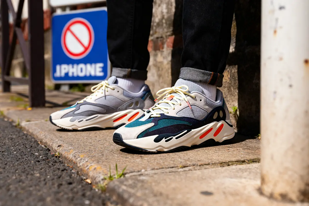 Chaussures de sport colorées portées par une personne, panneau d'interdiction en arrière-plan sur le trottoir.